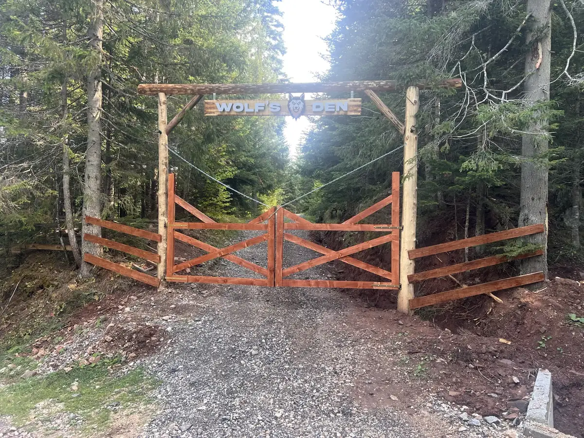 The wooden Wolf's Den gate on the forest road