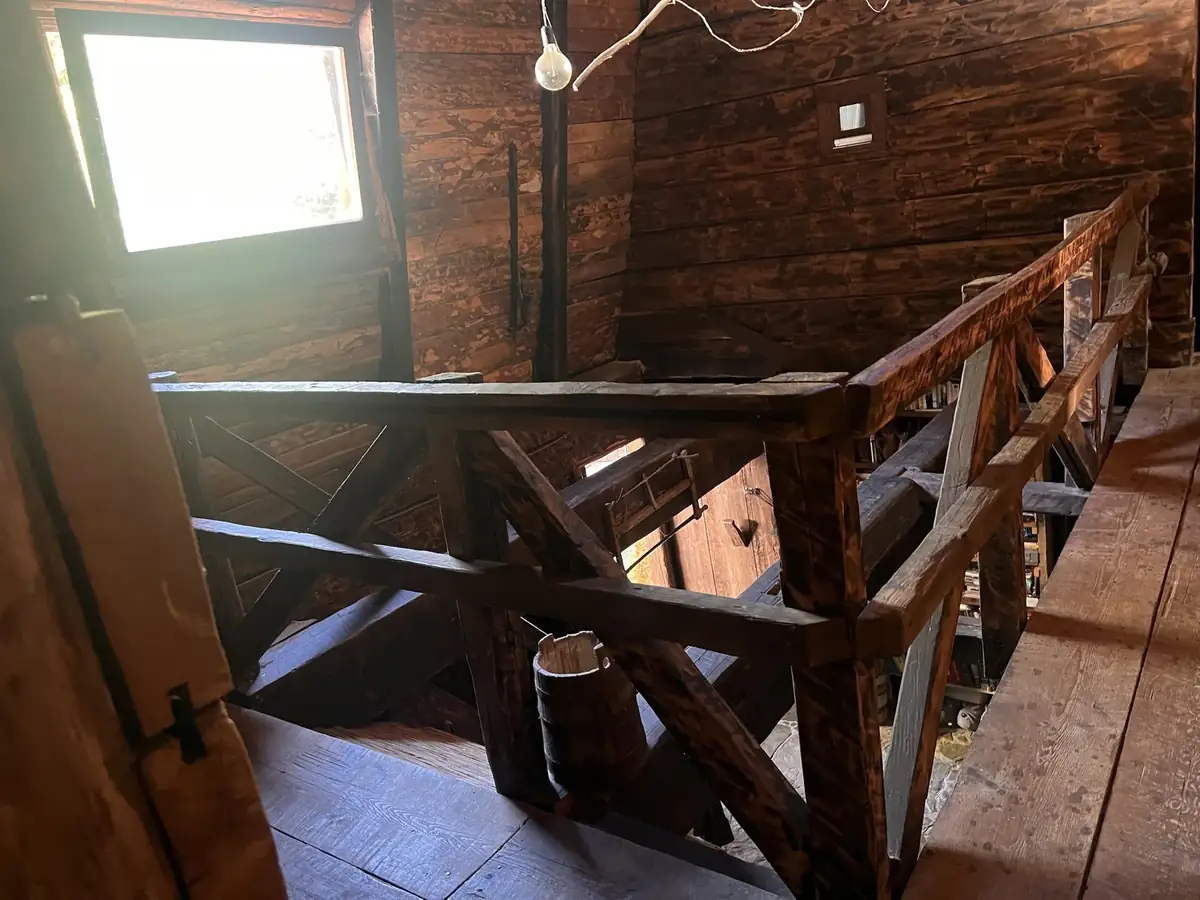 Top floor landing with a timber railing and a small window