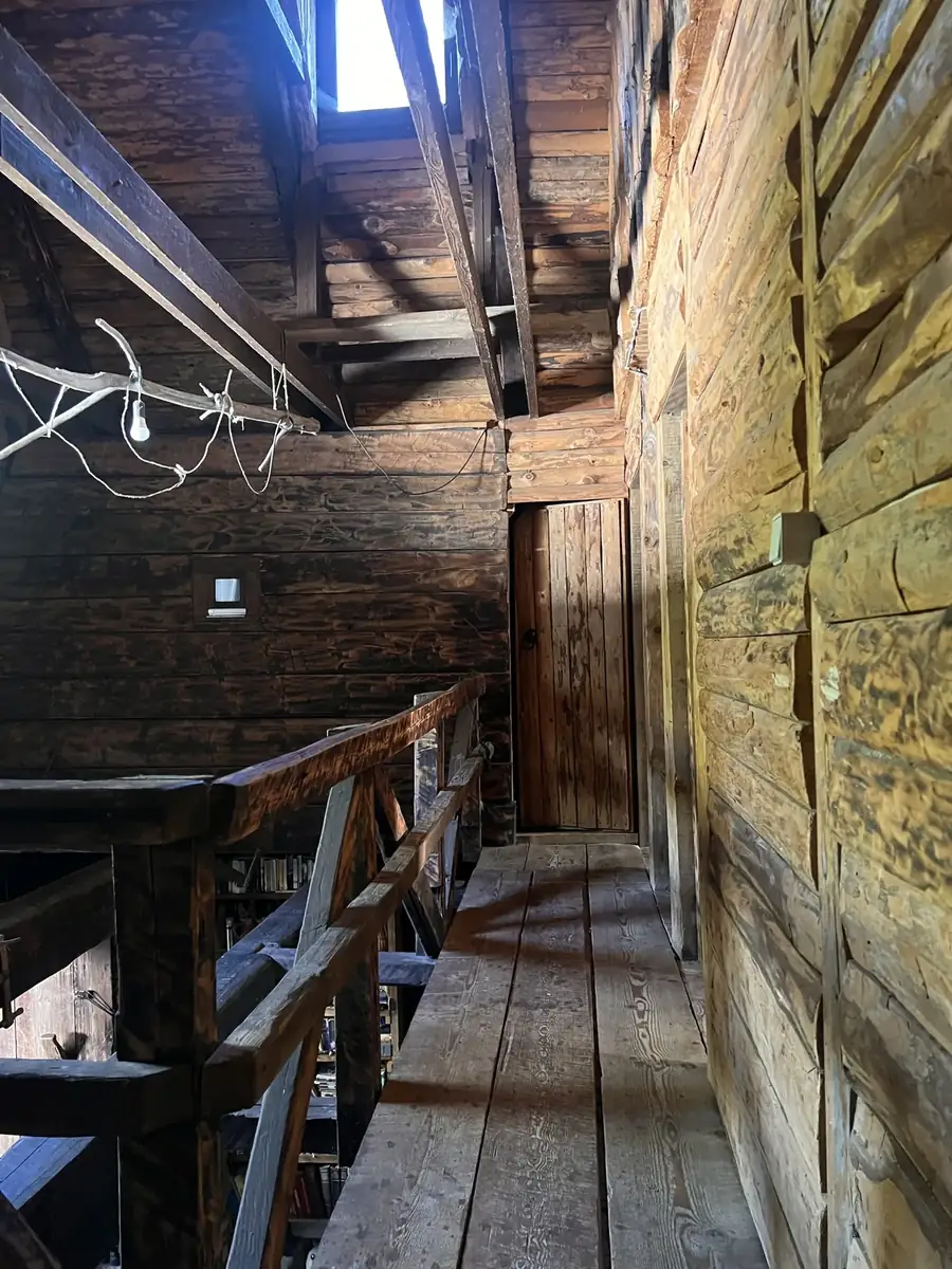 Upstairs walkway along log walls under the roof beams